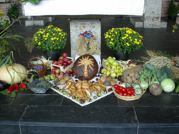 Zu Erntedank liegen vor einem Altar Gaben wie Obst, Gemüse, Blumen und Brot.